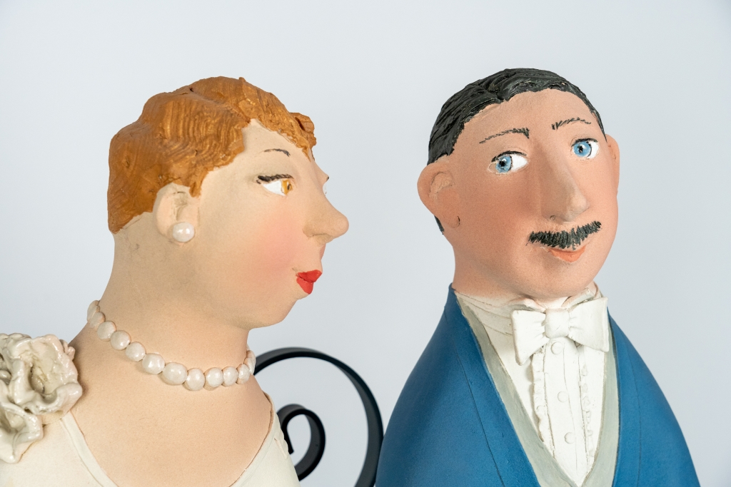 Gros plan sur le couple amoureux 19 d’Evelyne Almayrac, sculpture unique en grès réfractaire représentant un couple sur un banc en fer forgé.