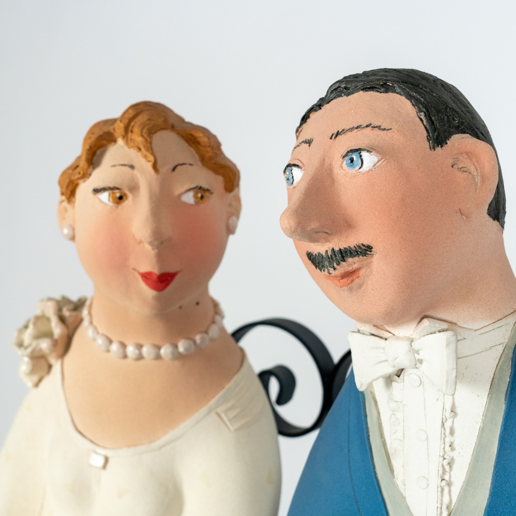 Zoom sur le couple amoureux 19 d’Evelyne Almayrac, sculpture unique en grès réfractaire représentant un couple sur un banc en fer forgé.