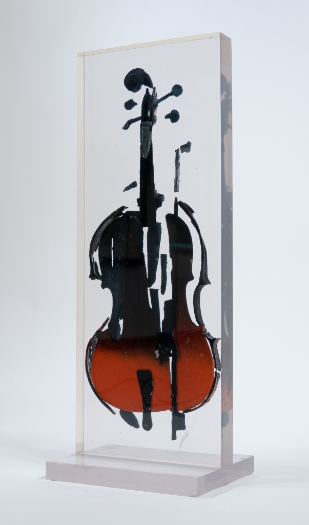 Vue de trois quarts du violon calciné inclusion d’Arman, œuvre intégrant un violon fragmenté et brûlé, conservé dans une inclusion transparente, emblématique de la démarche de déconstruction de l’artiste.