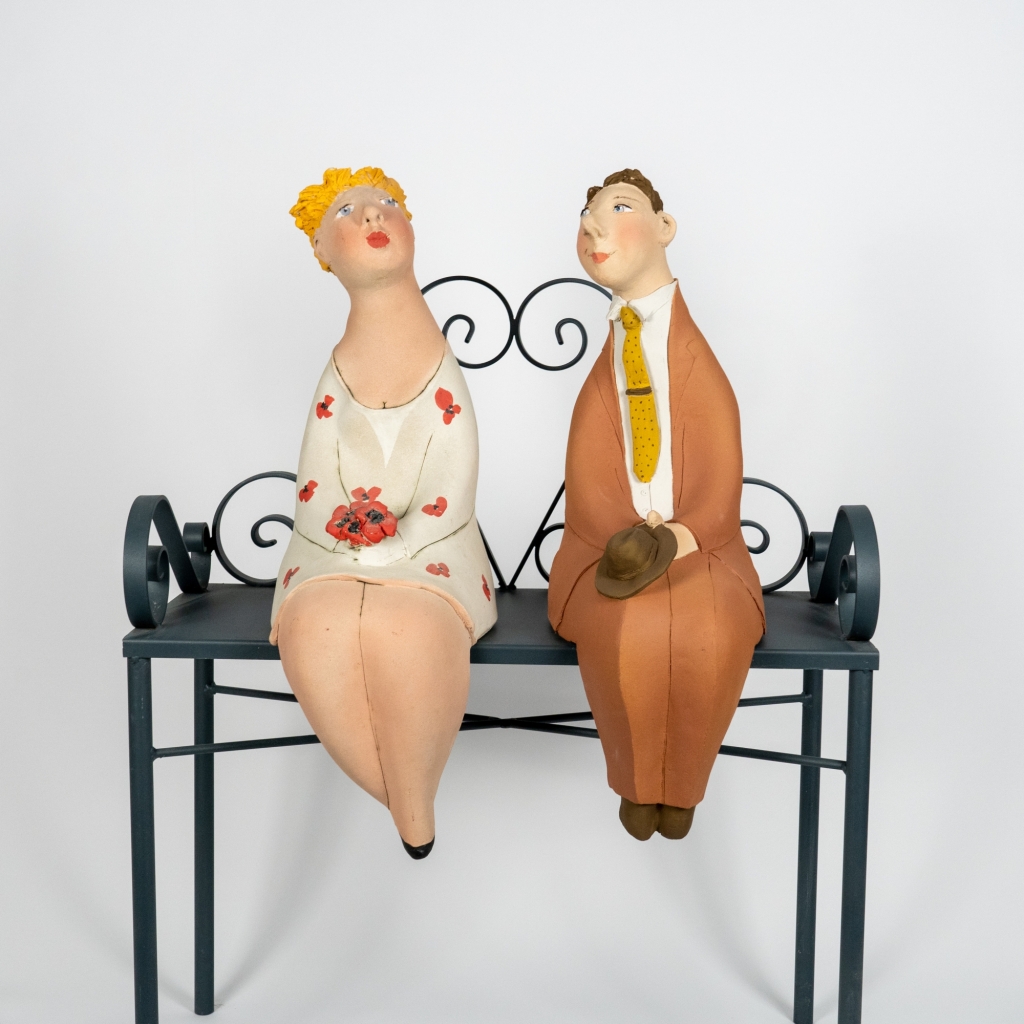 Couple amoureux 18 d’Evelyne Almayrac, sculpture unique en grès réfractaire représentant un couple assis côte à côte sur un banc en fer forgé.