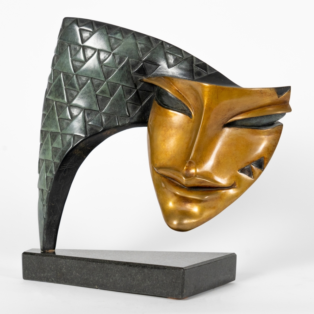 Arlequin d'Arsen Avetissian, sculpture contemporaine en bronze représentant un masque stylisé suspendu à une arche finement texturée de motifs géométriques. Son regard mi-clos et son sourire énigmatique évoquent le célèbre personnage de la Commedia dell'arte.