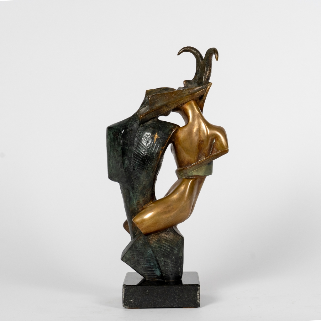 Dos de Capricorne d’Arsen Avetissian, sculpture contemporaine en bronze représentant un couple enlacé. La figure féminine, coiffée de cornes de capricorne, enlace une silhouette masculine stylisée dans une composition élégante aux patines dorées, brunes et vertes.
