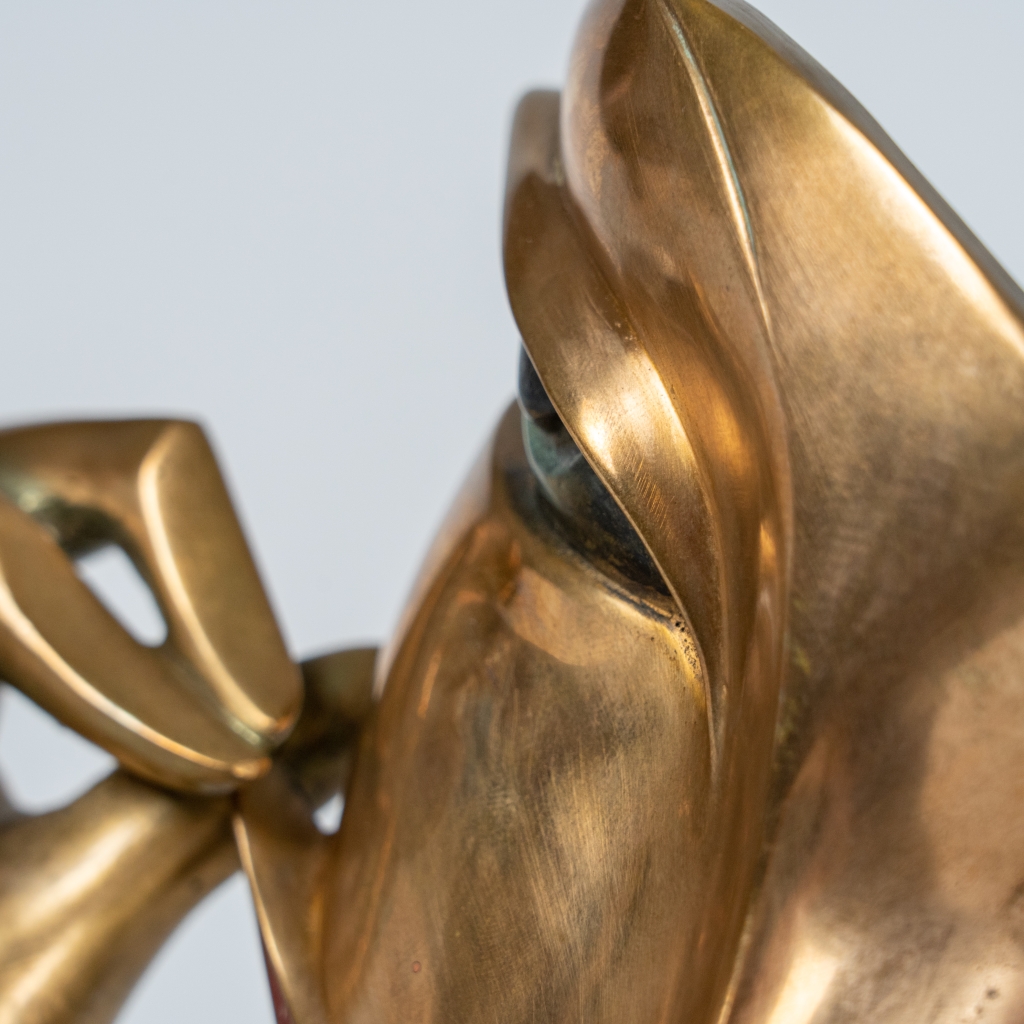 Zoom sur le visage de Jeu de sourire d'Arsen Avetissian, sculpture contemporaine en bronze représentant un visage stylisé aux lèvres esquissant un large sourire, encadré par deux mains élégamment levées qui semblent en souligner l'expression. L'œuvre repose sur un socle en pierre et joue sur l'équilibre entre humour, élégance et raffinement.