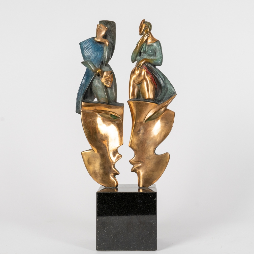 Mascarade III d'Arsen Avetissian, sculpture contemporaine en bronze représentant deux personnages stylisés dominant deux grands masques se faisant face. Les patines dorées, vertes et bleutées renforcent le caractère symbolique de cette composition élégante.