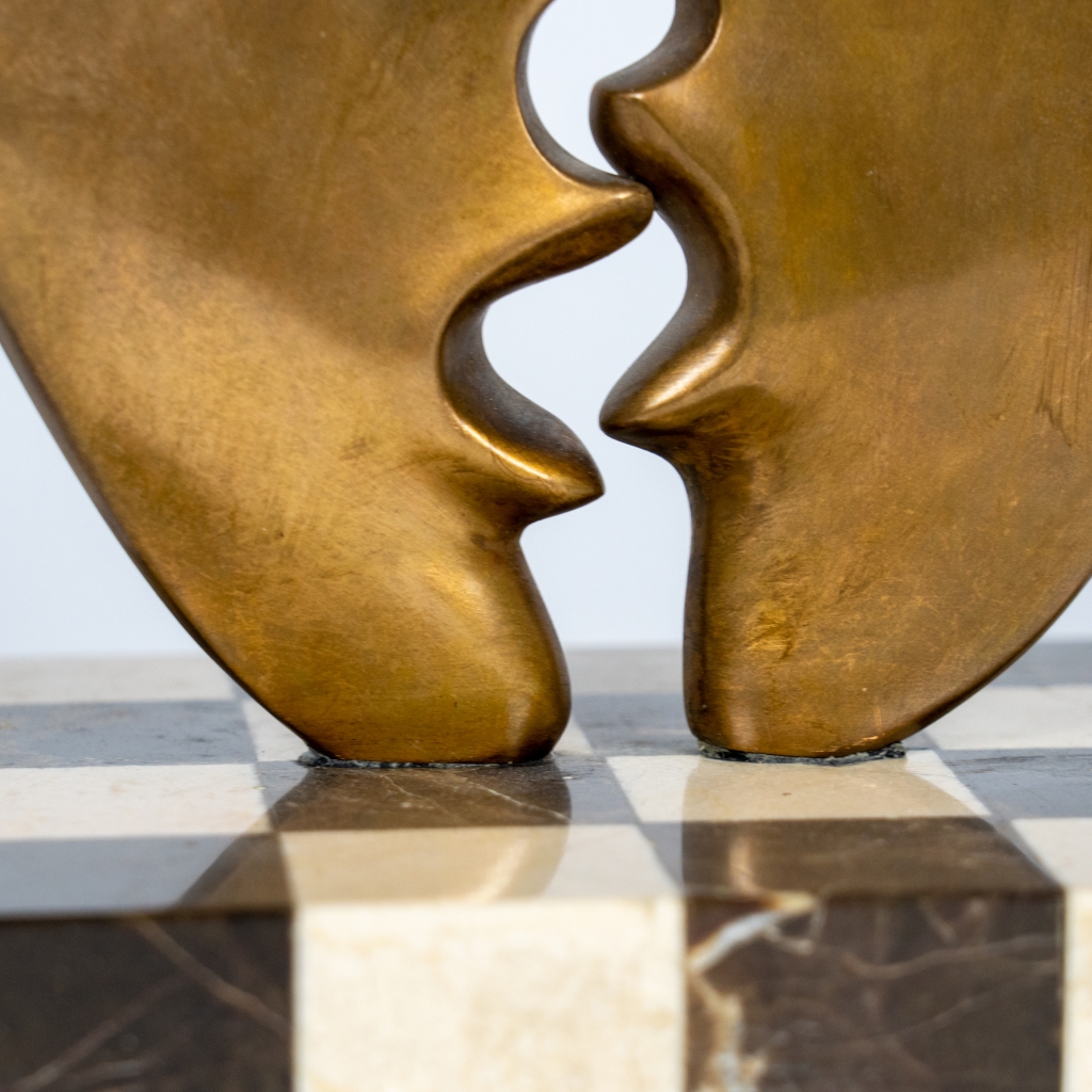 Gros plan sur les Visages de Musiciens ambulants II d'Arsen Avetissian, sculpture contemporaine en bronze représentant deux personnages stylisés installés dos à dos sur deux grands profils de visage.