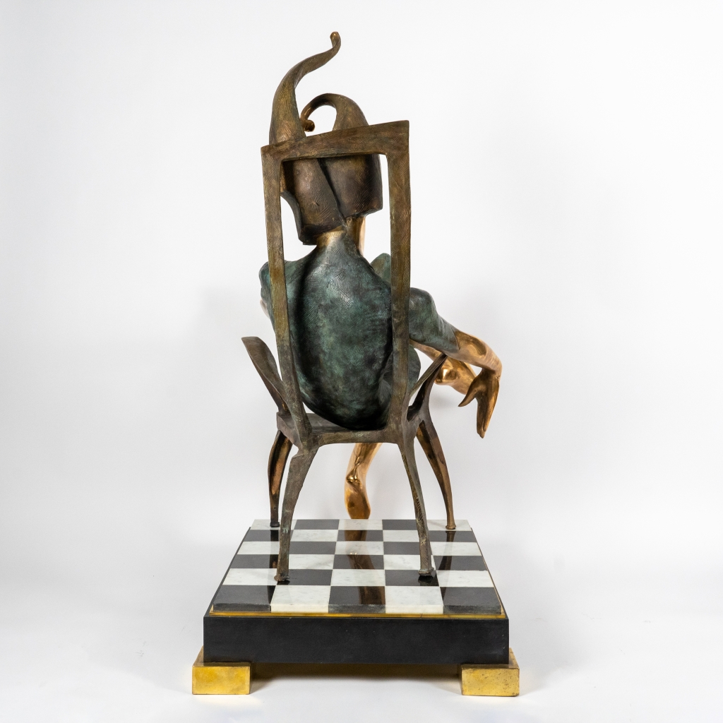 Dos de Le Roi de trèfle d’Arsen Avetissian, sculpture en bronze représentant un personnage royal stylisé assis sur un fauteuil. Installée sur un damier évoquant l’échiquier ou le jeu de cartes, l’œuvre mêle élégance, pouvoir et imaginaire ludique.