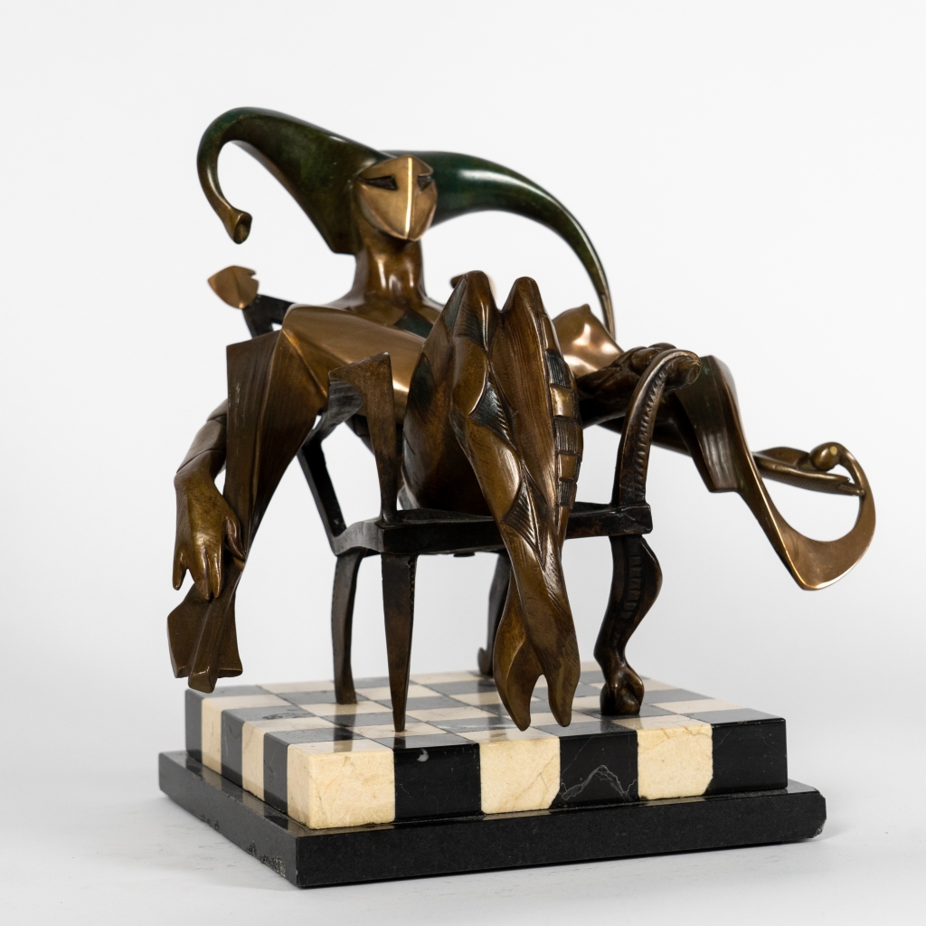Vue de trois quarts de Le Seigneur d'Arsen Avetissian, sculpture contemporaine en bronze représentant un personnage majestueux installé dans un fauteuil. Les jambes croisées, les bras largement ouverts et l'imposante coiffe en croissant composent une silhouette théâtrale évoquant l'autorité, la sérénité et l'élégance.