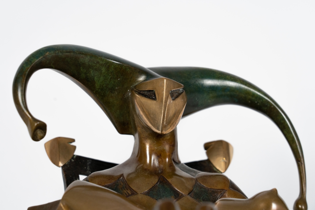 Zoom sur le visage de Le Seigneur d'Arsen Avetissian, sculpture contemporaine en bronze représentant un personnage majestueux installé dans un fauteuil. Les jambes croisées, les bras largement ouverts et l'imposante coiffe en croissant composent une silhouette théâtrale évoquant l'autorité, la sérénité et l'élégance.