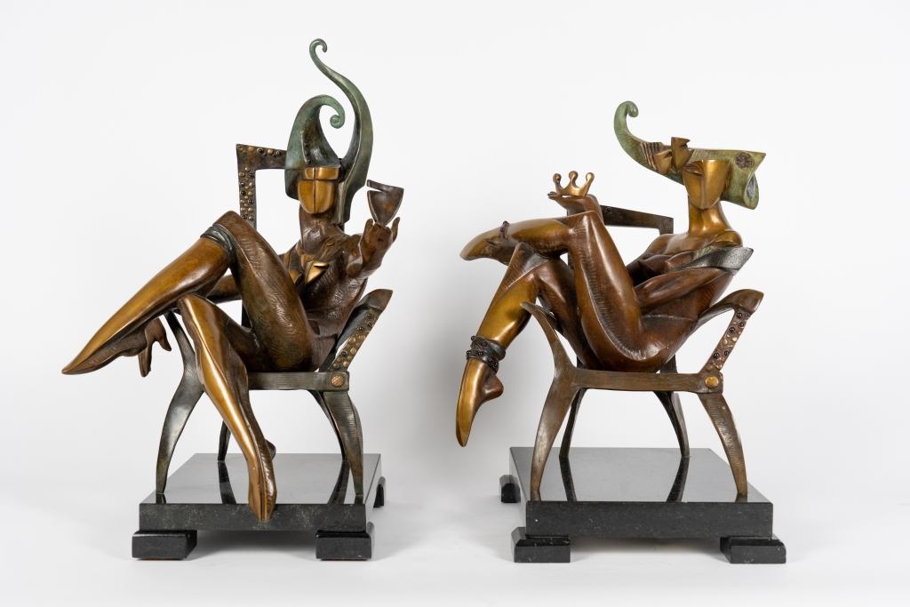 Vue du couple de The Queen of Club d'Arsen Avetissian, sculpture contemporaine en bronze représentant une reine élégamment installée dans un fauteuil. Les jambes repliées, les bras croisés et la coiffe monumentale évoquent une souveraine à la fois mystérieuse, indépendante et pleine d'assurance.