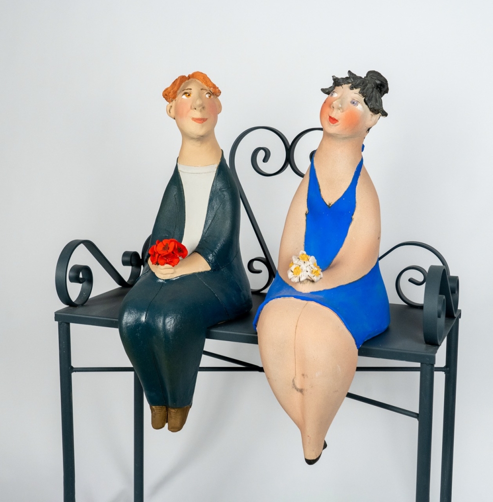 Vue de trois quarts du couple amoureux 17 d’Evelyne Almayrac, sculpture unique en grès réfractaire représentant un homme et une femme assis sur un banc en fer forgé.