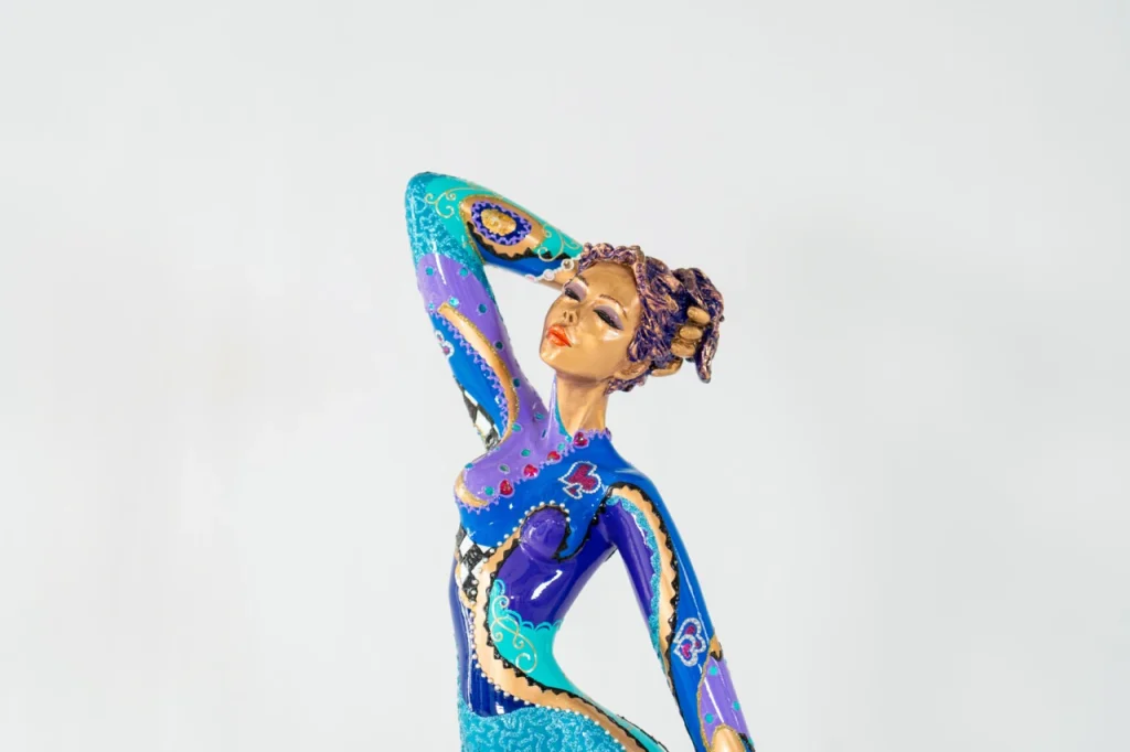 Vue de la sculpture en bronze peint La Perle de Josepha, figure féminine élancée aux nuances de bleu et violet dans une posture élégante et raffinée.