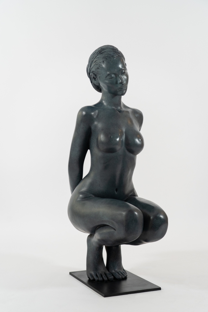 Vue de 3/4 de la Sculpture en bronze de Marie Paule Deville Chabrolle, Birdy, femme nue et élégante accroupie sur la pointe des pieds, elle parait pensive