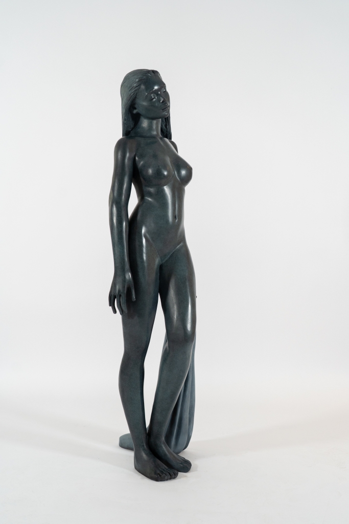 Sculpture en bronze de Marie Paule devine Chabrolle, libre et nue sur la rivière, figure féminine debout, nue et élégante tenant un tissus dans la main gauche, proportions idéales avec de belles formes, patine foncée
