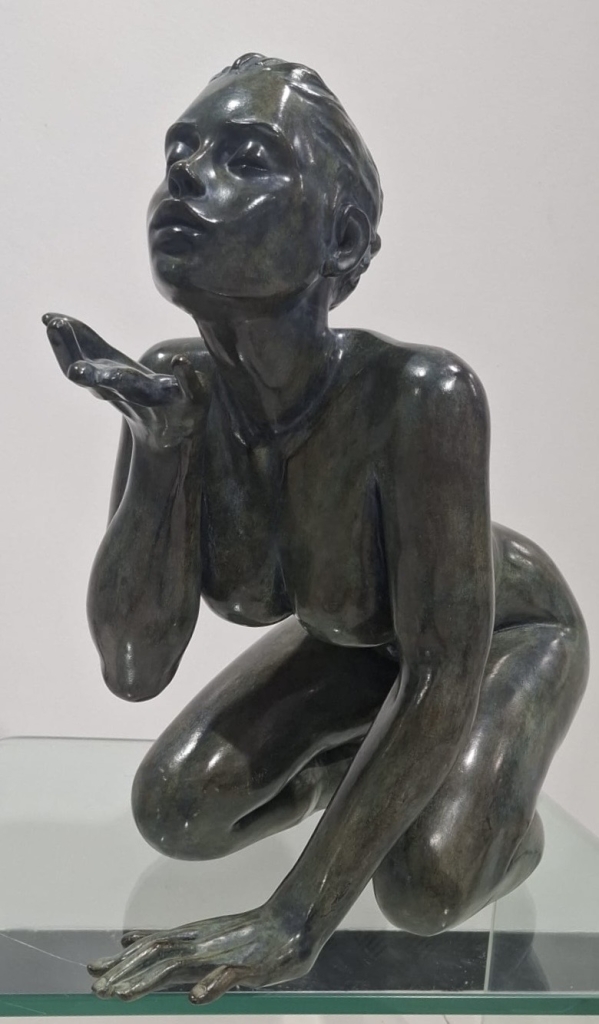 Sculpture en bronze de Marie Paule Deville Chabrolle, le baiser, femme élégante à genoux soufflant sur sa main pour envoyer un baiser, patine vert de gris
