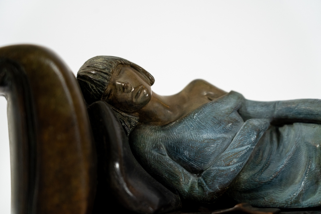 Détail de cette magnifique oeuvre de petit format réalisée en bronze par Annabelle DELAIGUE suivant la technique de fonte à la cire perdue représentant ici une femme allongée sur son divan un livre à la main. Patine travaillée à merveille