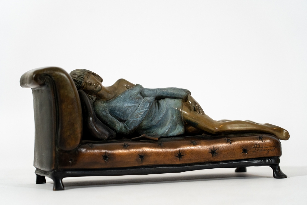 Magnifique oeuvre de petit format réalisée en bronze par Annabelle DELAIGUE suivant la technique de fonte à la cire perdue représentant ici une femme allongée sur son divan un livre à la main. Patine travaillée à merveille