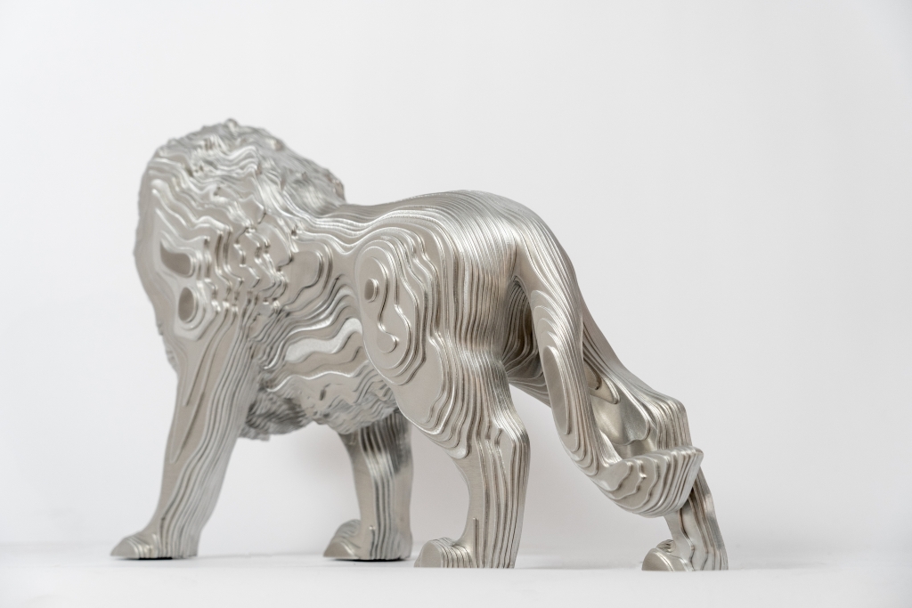 Vue de la sculpture en aluminium Kasimba de Jean-Paul KALA, lion majestueux aux lignes fluides et contemporaines, symbole de puissance et de noblesse.